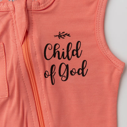 A close-up detail shot of the chest on the Apostle Living Inc. pink romper, highlighting the black "Child of God" script and the orange zipper.