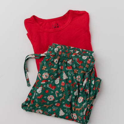 A flat lay of the Apostle Living Inc. men's Christmas pajama set, showing the red long-sleeve top folded on top of the festive green-and-white patterned pants.